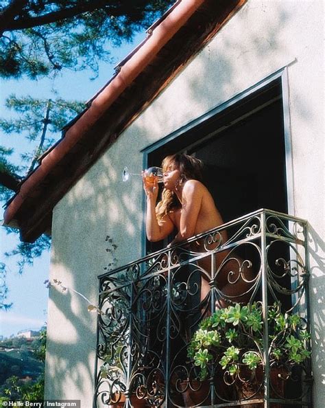 Halle Berry, 56, poses NUDE on balcony as she sips from glass。